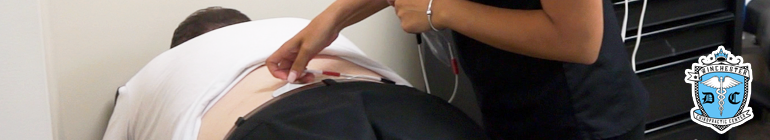A patient's lower back is receiving electrical stimulation.