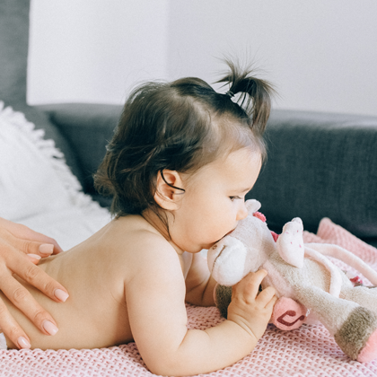 A close up view of a pregnant woman holding her belly, being that a child is developing.